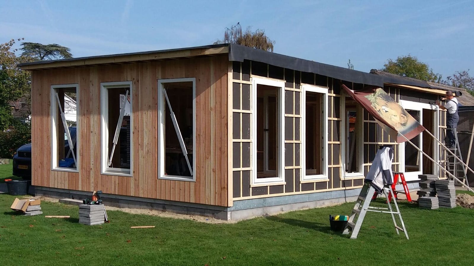 Woning in opbouw met kunststof kozijnen en gedeeltelijke afwerking in verticale houten gevelbekleding – Toelevering Online