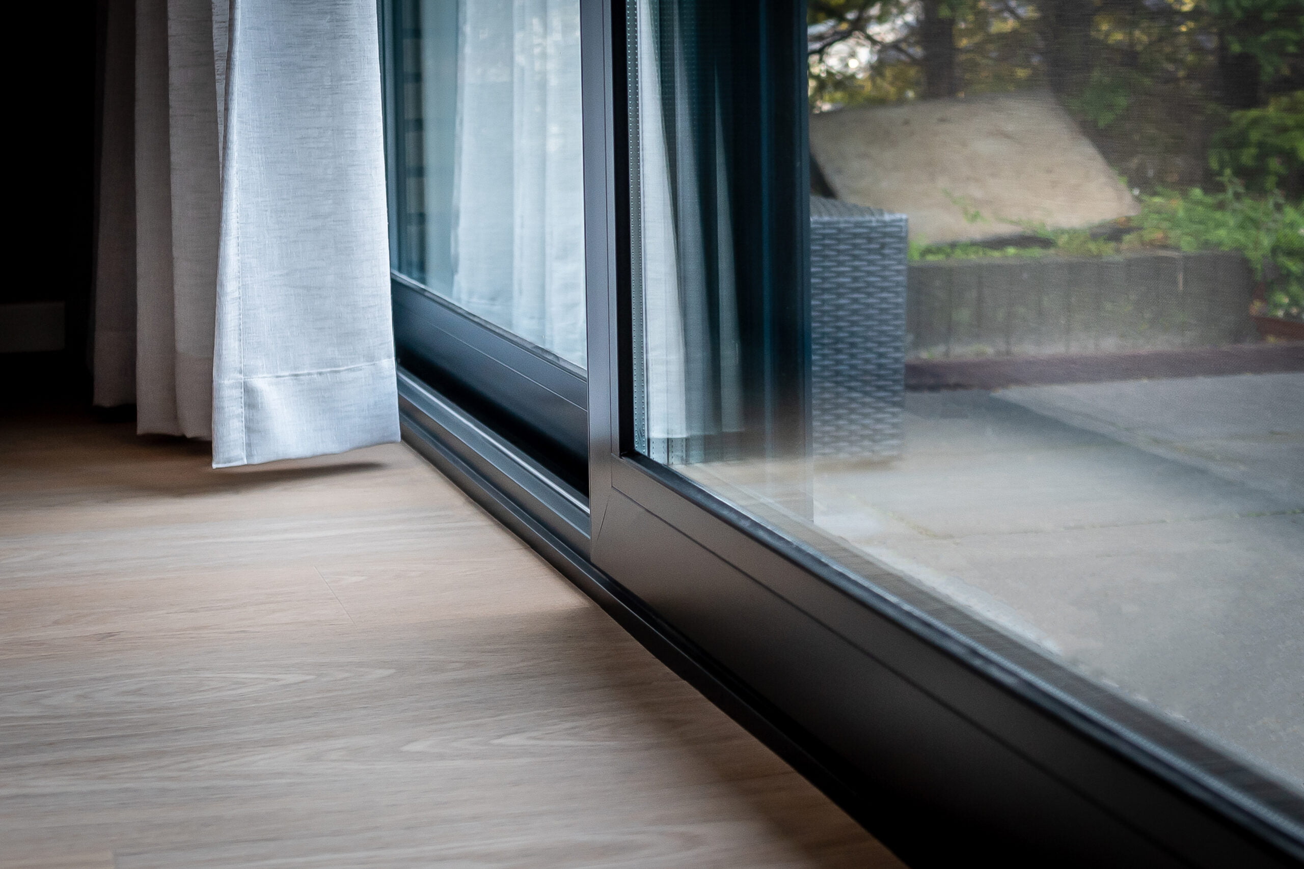 Close-up van aluminium Reynaers CP130 schuifpui met vlakke dorpel en aansluiting op houten vloer – Toelevering Online